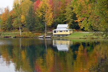 Fototapeta na wymiar Yellow Cottage Reflection On Autumn Pond
