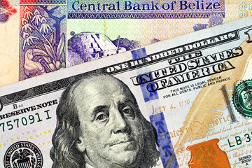 A macro image of a Belize two dollar bill in macro with a blue American one hundred dollar bill