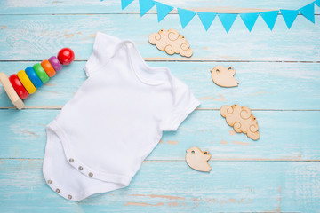 mockup Flat Lay white baby shirt with wooden toys on a blue background. Layout for design and...
