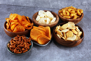 Salty snacks. Pretzels, chips, crackers in wooden bowls.