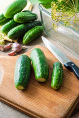 Fresh cucumbers on wooden board prepared for pickling