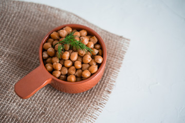 casserole of chick-peas cooked on white fund.boiled chickpeas in a clay pot close up. copy spase.Boiled chickpeas in a bowl.traditional Turkish cuisine