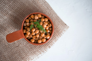 casserole of chick-peas cooked on white fund.boiled chickpeas in a clay pot close up. copy spase.Boiled chickpeas in a bowl.traditional Turkish cuisine
