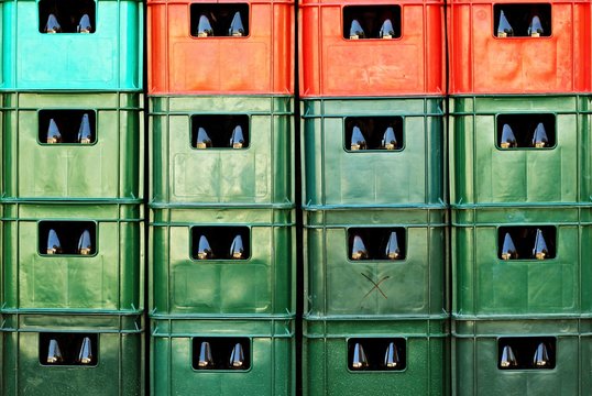 Full frame of plastic colorful beer crates stacked one upon the other. Abstract background