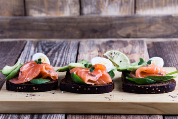 Toasted rye bread with  smoked salmon and fresh green vegetables