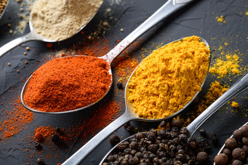 Various spices spoons on stone table.On dark concrete background.Herbs and spices on wooden table.  Top view with space for your text