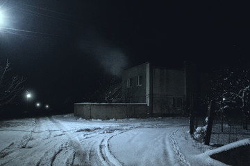 house with smoke at night in winter