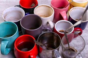 Empty dirty coffee cups of different colors on the table. Concept of caffeine dope, lack of energy...
