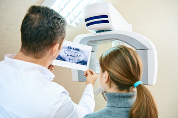 The doctor shows the patient an x-ray image. Computer diagnostics. dental tomography