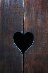 Background. Wooden surface painted with blue and brown paint. In the middle is a carved figure of a heart. Daylight shooting