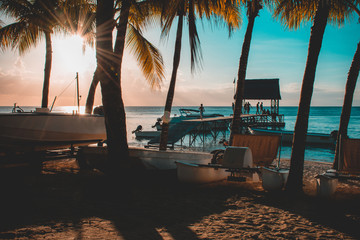 Beautiful sunset in Trou aux Biches, Mauritius. View of the jetty and boats amidst palm trees
