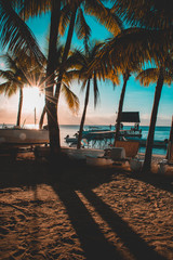 Beautiful sunset in Trou aux Biches, Mauritius. View of the jetty and boats amidst palm trees