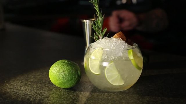 The bartender prepares a cocktail Cassis Caipirinha (Caipirissima, Caipiroska). Pours liquor on ice frappe.