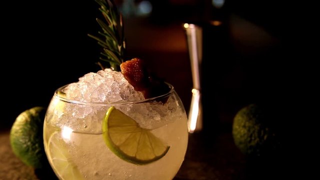 The bartender prepares a cocktail Cassis Caipirinha (Caipirissima, Caipiroska). Pours liquor on ice frappe.