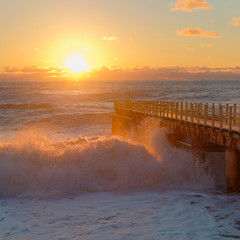 Yellow sun lights big storm waves. Sunset on the sea. Beautiful nature.