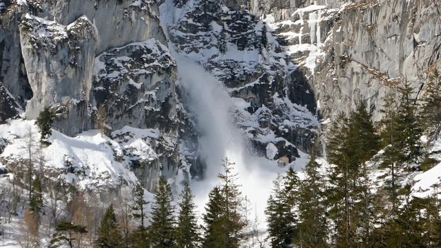 Small avalanche, snow flowing from cliff