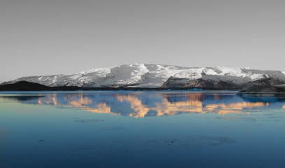 Fototapeta na wymiar Iceland's Jökulsárlón Glacier Lagoon in sunrise, black and white with reflection in color. 