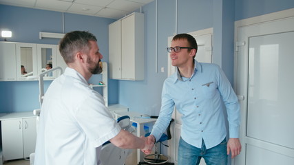 Doctor Welcoming the Patient at Visit and Inviting to the Dentist Chair Starting Consultation in the Stomatology Clinic