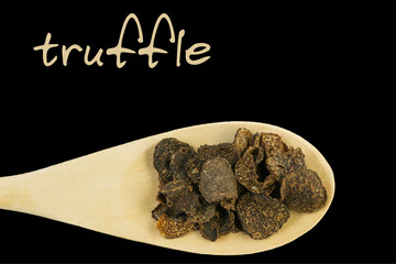 truffle on wooden spoon isolated on black background
