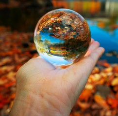 Crystal Ball nestled in palm of my hand, reflecting a covered bridge in Maine