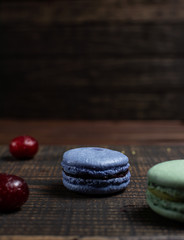 Colorful macaroons lie on a wooden background. Menu design, place for text.