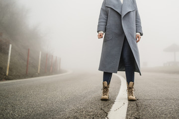 woman standing on the open road in fog