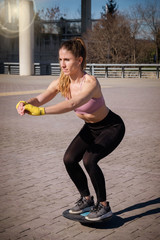 Closeup portrait of a Fitness girl doing pushups on a park during a blue and sunny day