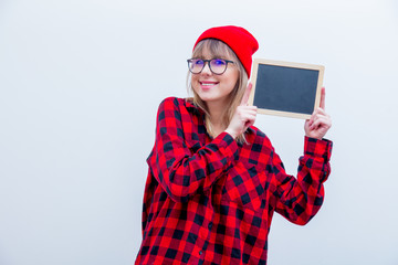 Young woman in red shirt and hat with blackboard