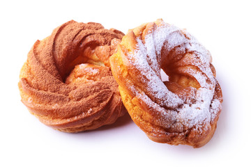 Chocolate and powdered sugar cream puff rings, choux pastry. Isolated on white background.