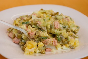 salad with mayonnaise on a white plate with a spoon