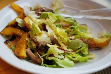 a portion of fresh salad on a white plate with a fork