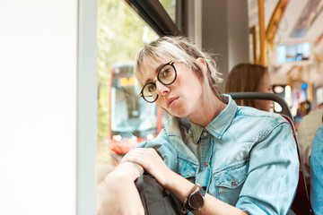 Pensive young woman in the city bus
