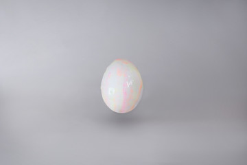 light, slightly colored egg on grey background.