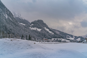 Fototapeta na wymiar Winter evening landscape of snowy mountains in Saanen, Switzerland