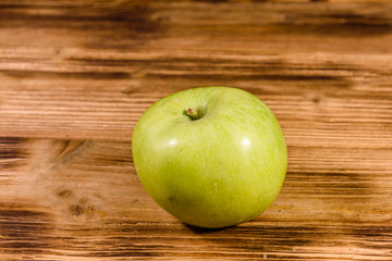 Ripe green apple on a wooden table