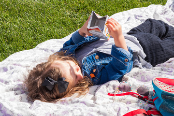 Child eating snacks on blanket in the sun