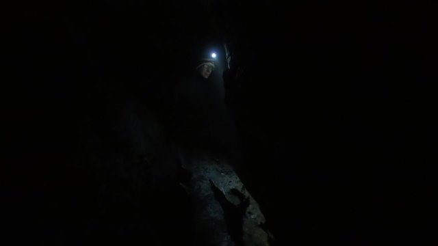 Caver in the dark explores her surroundings