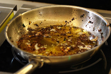 Frying pan with used oil on a stove after cooking