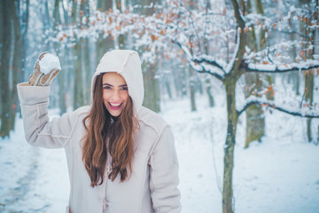 Winter portrait of young beautiful brunette woman in snow Garden. People in snow. Woman winter...