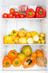Opened fridge full of fresh colorful fruits and vegetables