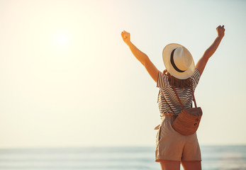 happy tourist girl with backpack and hat on sea.