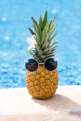 Creative food and travel concept card with hipster ananas in glasses