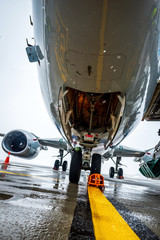 Aircraft, nose close up. Airplane maintenance and plane preparation for departure. Bad weather at...