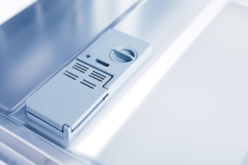 Detail of empty dishwasher with detergent dispensers, no people