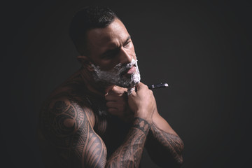 Bearded man getting haircut by hairdresser and sitting in chair at barbershop. Bearded client visiting barber shop. Bearded man. So trendy and stylish. Hair salon and barber vintage.