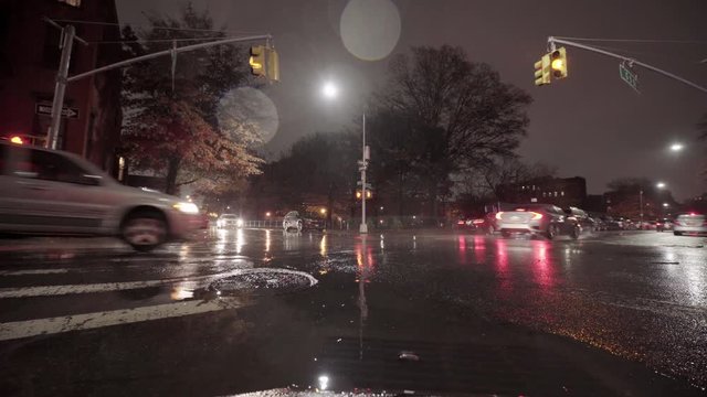 Car Going Through Rain Puddle in City at Night and Car Running Red Light