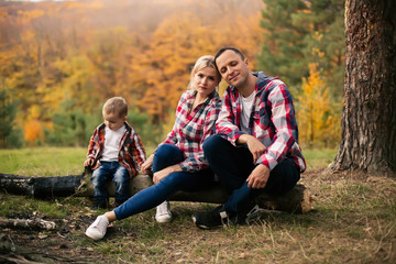 Young family with little son spend time in forest