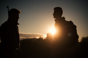 Silhouette of the hunters. Rifle Hunter Silhouetted in Beautiful Sunset.