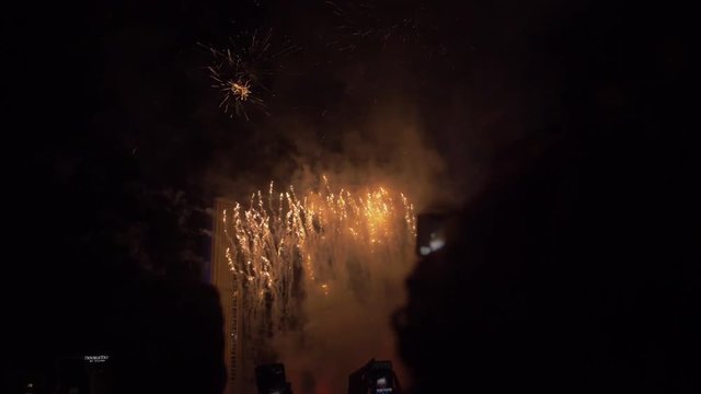 POV of a group of unrecognizable people filming a fireworks display on there mobile phones, a conceptual shot in slow motion.