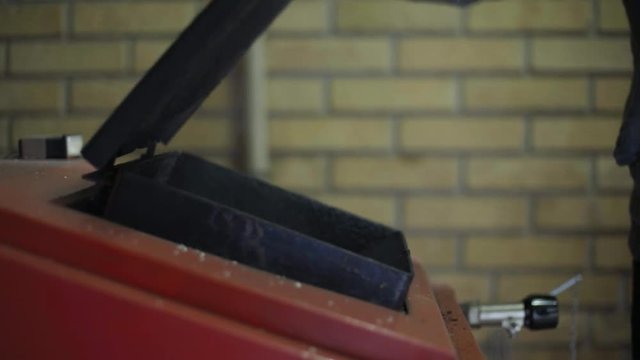 Man starting up wood stove
